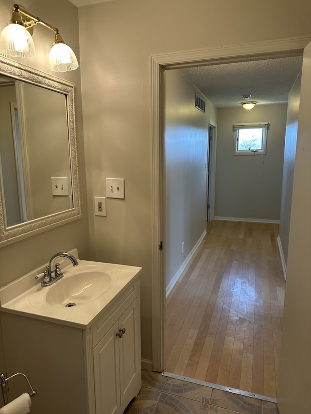 1326 Post Oak Ct Unit 1, Crest Hill, IL 60403 - bathroom featuring vanity, baseboards, a textured ceiling, and hardwood / wood-style flooring