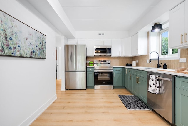 7925 Paxton Ave Unit 1A, Tinley Park, IL 60477 - kitchen with appliances with stainless steel finishes, green cabinets, white cabinets, tasteful backsplash, and light countertops