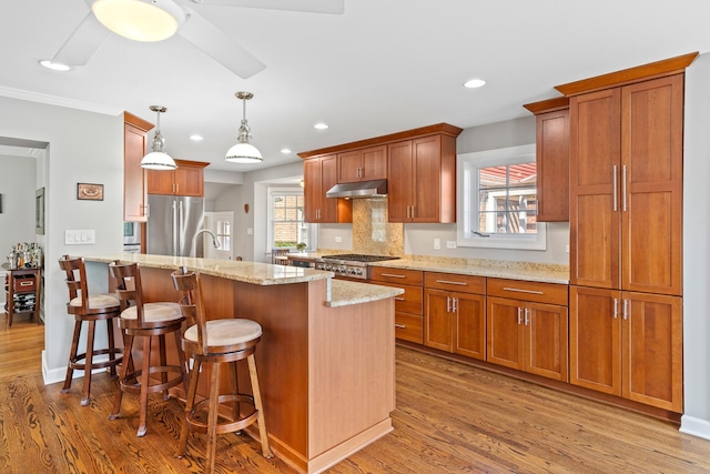 7317 W Greenleaf St, Chicago, IL 60631 - kitchen with stainless steel appliances, wood finished floors, a breakfast bar, light stone counters, and recessed lighting