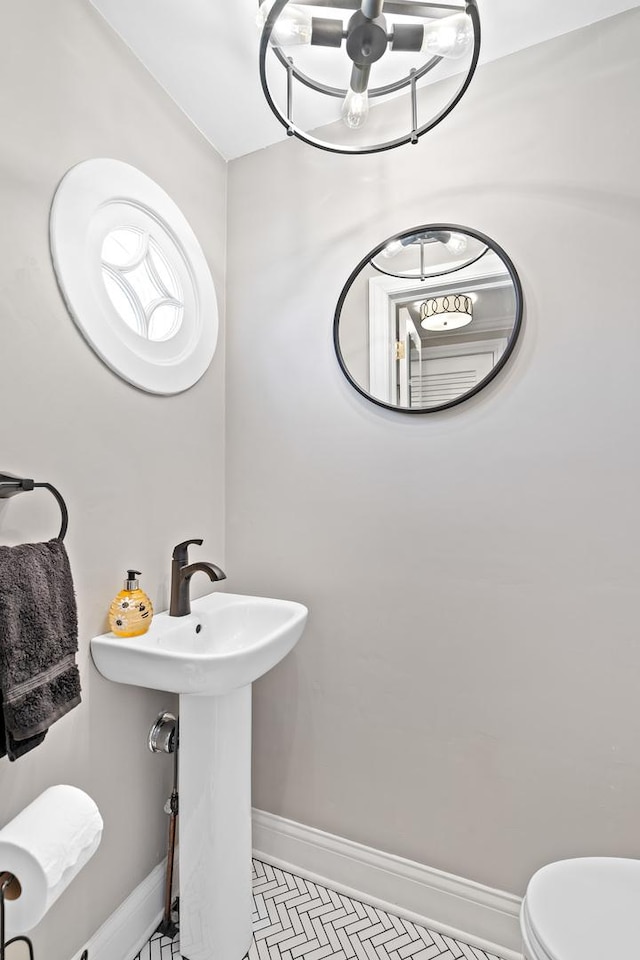 7317 W Greenleaf St, Chicago, IL 60631 - bathroom featuring baseboards, a chandelier, and toilet
