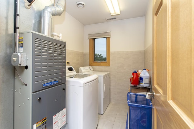 5148 S Newland Ave, Chicago, IL 60638 - laundry area featuring tile walls, light tile patterned floors, washing machine and clothes dryer, a wainscoted wall, and heating unit