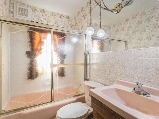 530 Fitch Rd, Rockford, IL 61109 - bathroom with wallpapered walls, toilet, enclosed tub / shower combo, vanity, and tile walls
