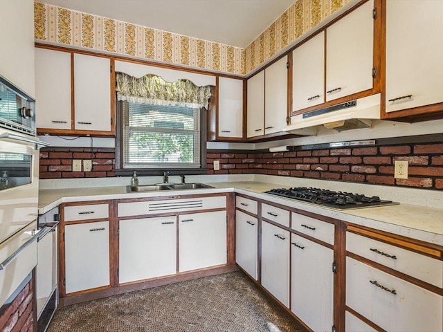 530 Fitch Rd, Rockford, IL 61109 - kitchen featuring a sink, stainless steel gas cooktop, under cabinet range hood, light countertops, and white cabinets