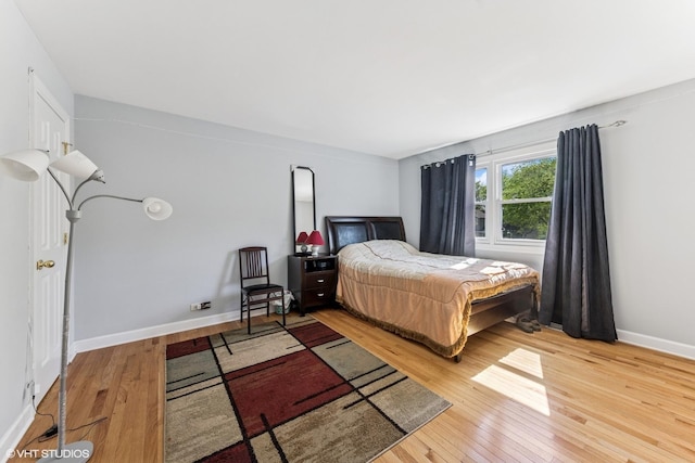bedroom with hardwood / wood-style flooring and baseboards