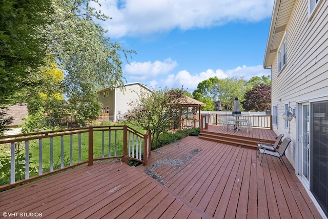 deck featuring a gazebo and outdoor dining area