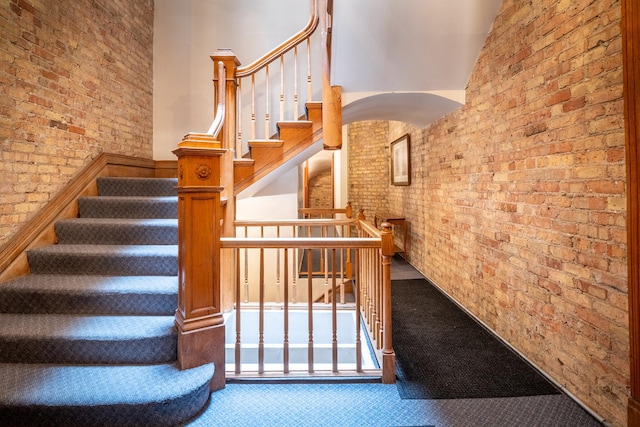 3711 N Pine Grove Ave Unit 2Nw, Chicago, IL 60613 - staircase featuring brick wall, carpet floors, and a towering ceiling