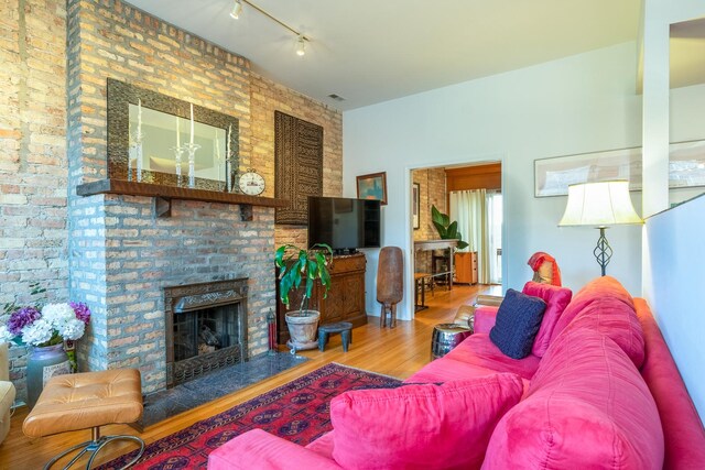 3711 N Pine Grove Ave Unit 2Nw, Chicago, IL 60613 - living room featuring wood finished floors, track lighting, and a fireplace