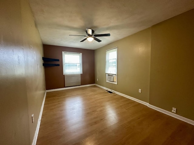 509 E Webster St, Clinton, IL 61727 - empty room featuring a ceiling fan, wood finished floors, baseboards, and cooling unit