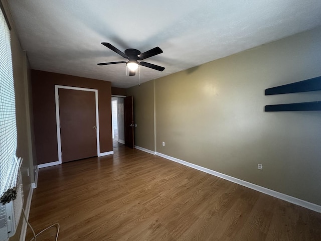 509 E Webster St, Clinton, IL 61727 - unfurnished bedroom featuring wood finished floors, baseboards, and a ceiling fan