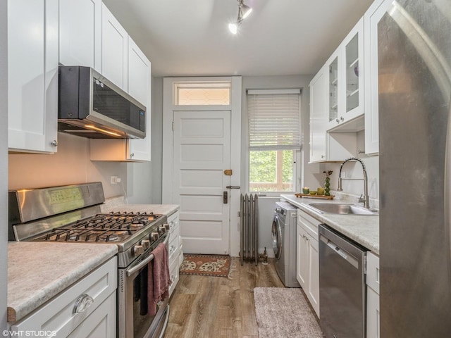2250 N Dayton St Unit 3, Chicago, IL 60614 - kitchen featuring appliances with stainless steel finishes, a sink, washer / clothes dryer, wood finished floors, and white cabinets