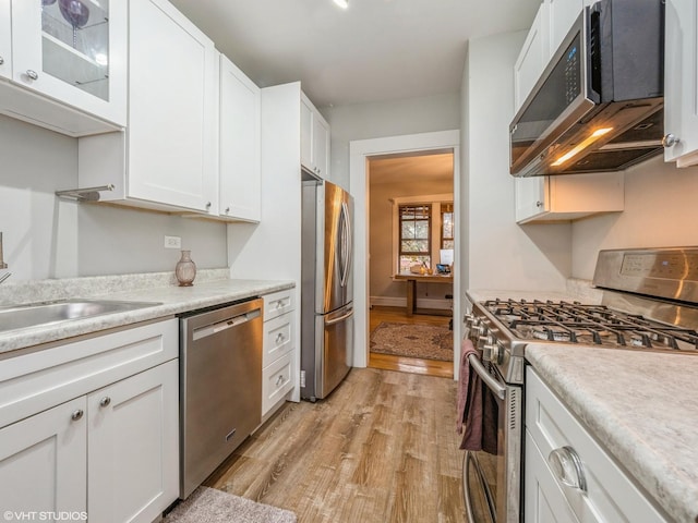 2250 N Dayton St Unit 3, Chicago, IL 60614 - kitchen featuring stainless steel appliances, light wood-style floors, white cabinets, light countertops, and glass insert cabinets