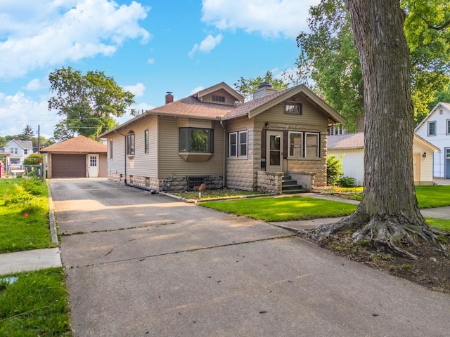 217 W Moulton St, Pontiac, IL 61764 - view of front facade featuring a chimney, an outbuilding, a detached garage, roof with shingles, and a front lawn