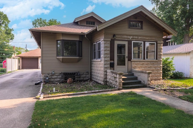 217 W Moulton St, Pontiac, IL 61764 - view of front facade featuring entry steps, a front lawn, roof with shingles, an outdoor structure, and a garage