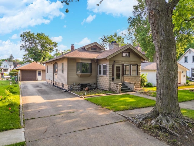217 W Moulton St, Pontiac, IL 61764 - bungalow-style house with a chimney, a garage, an outdoor structure, and a front lawn