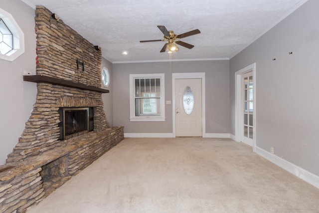217 W Moulton St, Pontiac, IL 61764 - unfurnished living room featuring ceiling fan, a stone fireplace, carpet, ornamental molding, and a textured ceiling