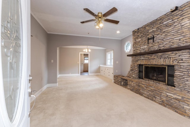 217 W Moulton St, Pontiac, IL 61764 - unfurnished living room featuring carpet, a ceiling fan, crown molding, and a stone fireplace