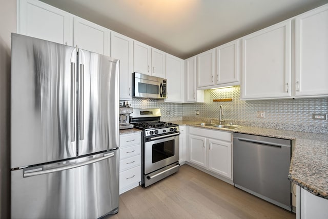 600 N Dearborn St Unit 2005, Chicago, IL 60654 - kitchen featuring stainless steel appliances, a sink, white cabinetry, and light wood finished floors