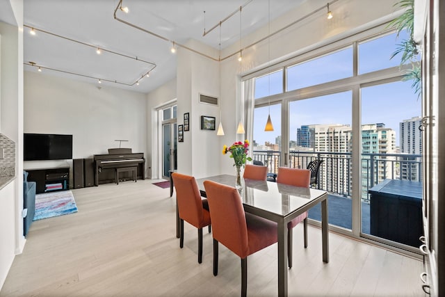 600 N Dearborn St Unit 2005, Chicago, IL 60654 - dining room featuring track lighting, a view of city, light wood-type flooring, and a high ceiling
