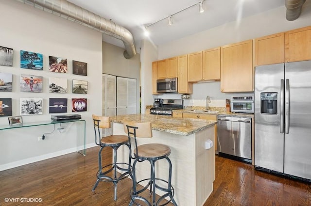 4011 N Francisco Ave Unit 301, Chicago, IL 60618 - kitchen with stainless steel appliances, light brown cabinetry, a sink, a center island, and a high ceiling