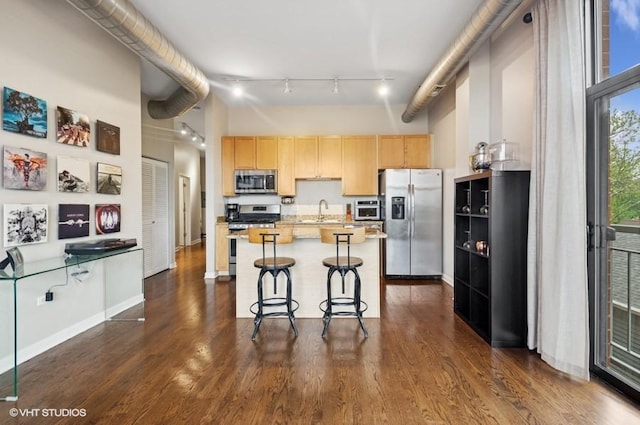4011 N Francisco Ave Unit 301, Chicago, IL 60618 - kitchen featuring stainless steel appliances, light brown cabinets, light countertops, dark wood-style floors, and a towering ceiling