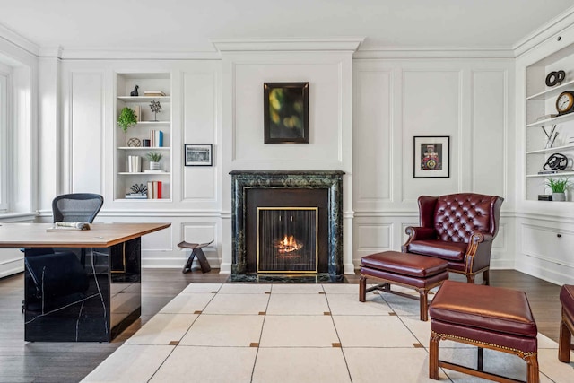 209 E Lake Shore Dr Unit 3W, Chicago, IL 60611 - sitting room with built in features, a decorative wall, a premium fireplace, ornamental molding, and wood finished floors