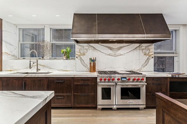 209 E Lake Shore Dr Unit 3W, Chicago, IL 60611 - kitchen with double oven range, wall chimney range hood, a sink, backsplash, and dark brown cabinetry