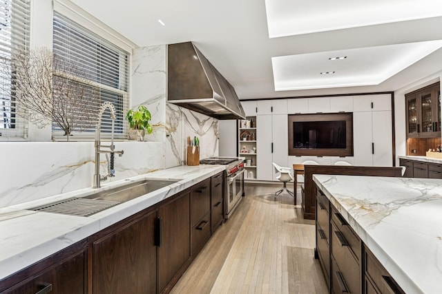 209 E Lake Shore Dr Unit 3W, Chicago, IL 60611 - kitchen featuring double oven range, a sink, wall chimney range hood, dark brown cabinetry, and light wood finished floors