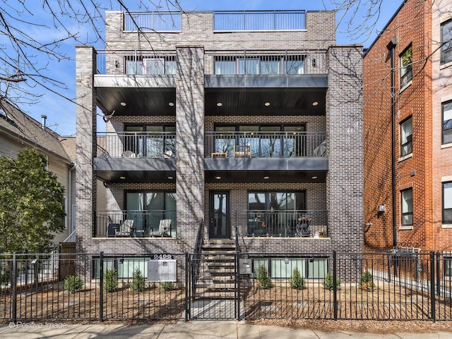 2422 W Lyndale St Unit 2, Chicago, IL 60647 - view of building exterior featuring a fenced front yard