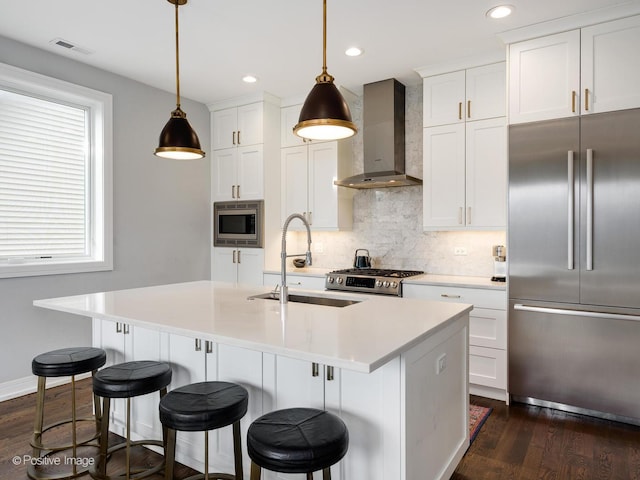 2422 W Lyndale St Unit 2, Chicago, IL 60647 - kitchen featuring built in appliances, wall chimney exhaust hood, a sink, dark wood-type flooring, and decorative backsplash