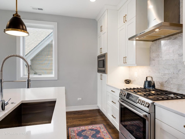 2422 W Lyndale St Unit 2, Chicago, IL 60647 - kitchen with stainless steel appliances, wall chimney range hood, a sink, dark wood-style flooring, and decorative backsplash