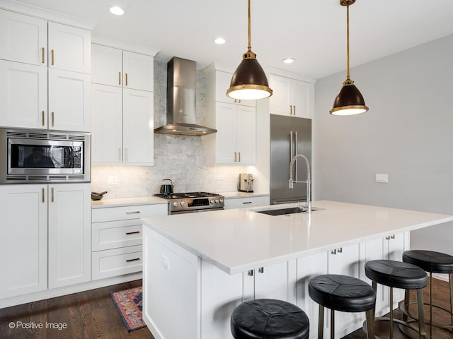 2422 W Lyndale St Unit 2, Chicago, IL 60647 - kitchen with wall chimney exhaust hood, appliances with stainless steel finishes, a sink, dark wood finished floors, and a kitchen island with sink
