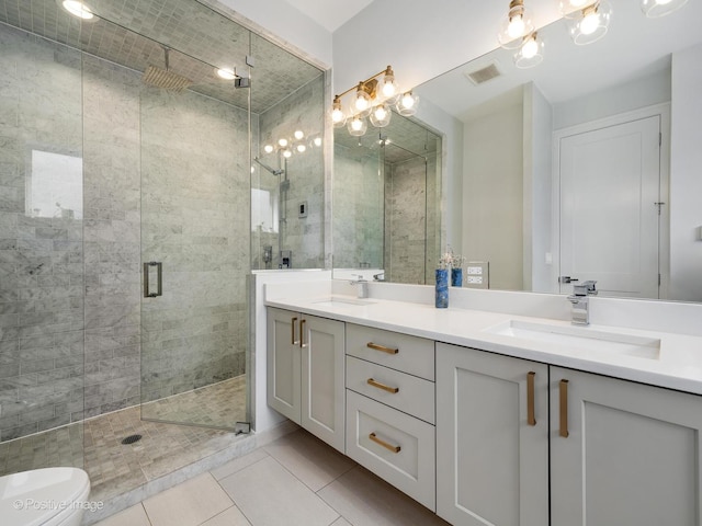 2422 W Lyndale St Unit 2, Chicago, IL 60647 - full bathroom featuring double vanity, a shower stall, tile patterned floors, and toilet