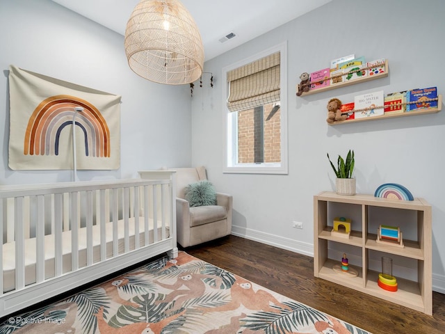 2422 W Lyndale St Unit 2, Chicago, IL 60647 - bedroom featuring baseboards, wood finished floors, and a crib