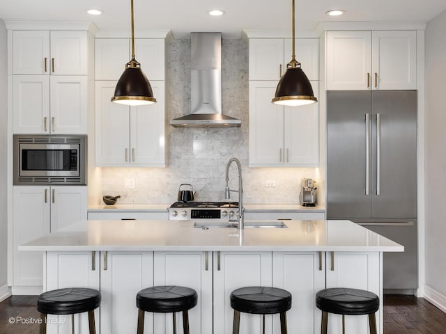 2422 W Lyndale St Unit 2, Chicago, IL 60647 - kitchen featuring stainless steel appliances, wall chimney exhaust hood, baseboards, light countertops, and recessed lighting