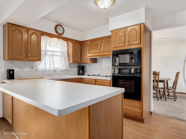 7514 Nantucket Dr, Darien, IL 60561 - kitchen with black appliances, light countertops, a peninsula, and backsplash