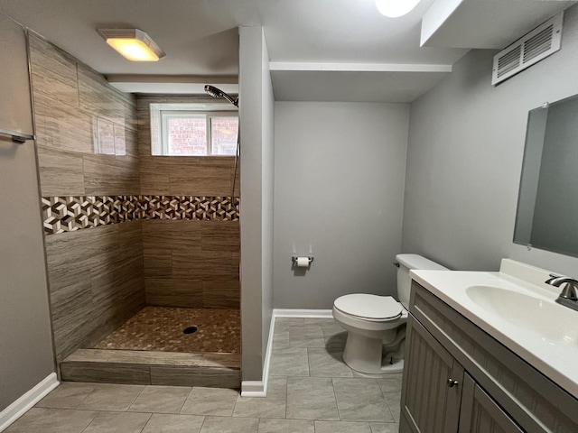 8920 S Jeffery Blvd, Chicago, IL 60617 - bathroom with vanity, a tile shower, toilet, tile patterned floors, and baseboards