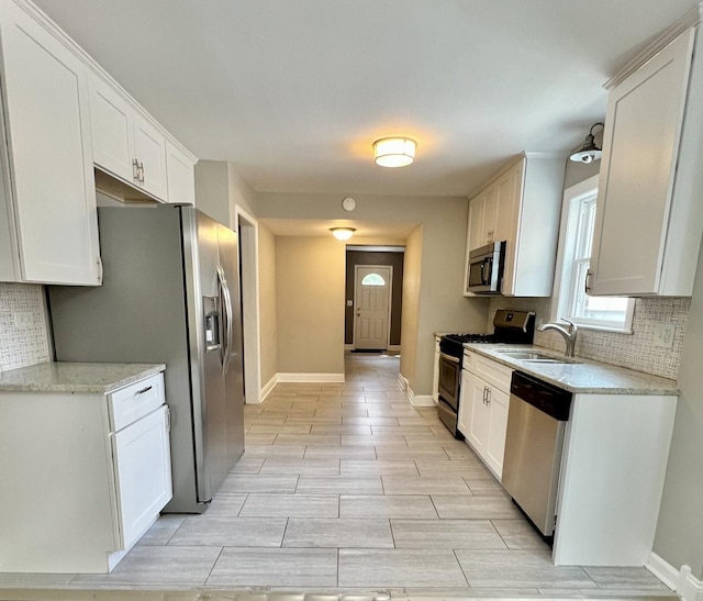 8920 S Jeffery Blvd, Chicago, IL 60617 - kitchen with stainless steel appliances, a sink, decorative backsplash, and white cabinets