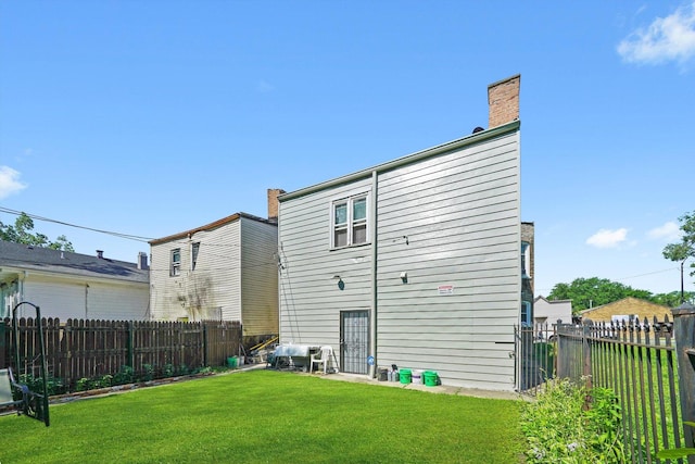 10807 S Wentworth Ave, Chicago, IL 60628 - back of house featuring a fenced backyard and a chimney