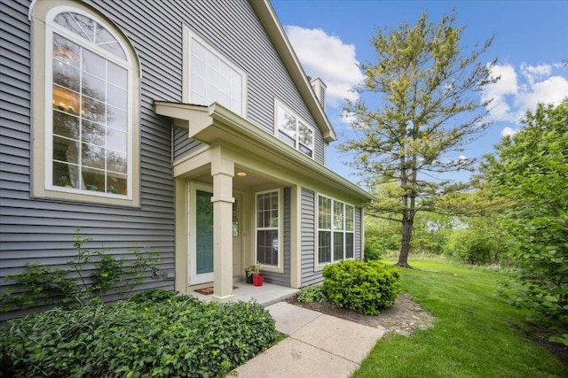1148 Coldspring Rd Unit 0, Elgin, IL 60120 - view of exterior entry featuring a yard and a chimney