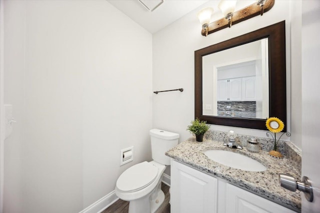 1148 Coldspring Rd Unit 0, Elgin, IL 60120 - half bathroom featuring baseboards, toilet, vanity, and wood finished floors