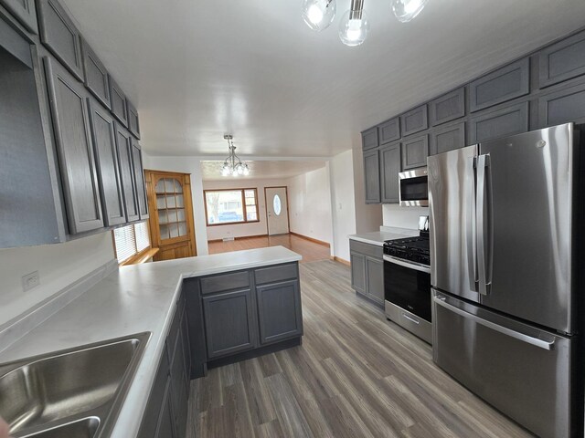 18433 Arcadia St, Lansing, IL 60438 - kitchen featuring appliances with stainless steel finishes, a chandelier, a sink, and dark wood-style flooring