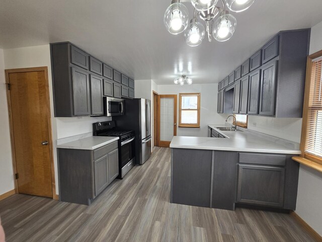 18433 Arcadia St, Lansing, IL 60438 - kitchen with appliances with stainless steel finishes, light wood finished floors, a chandelier, a sink, and light countertops
