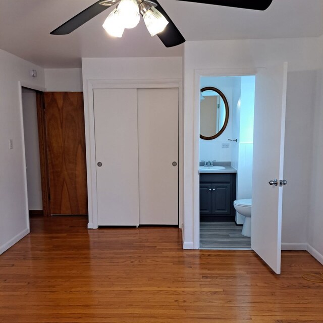 18433 Arcadia St, Lansing, IL 60438 - unfurnished bedroom with a closet, light wood-style floors, ensuite bathroom, baseboards, and a sink
