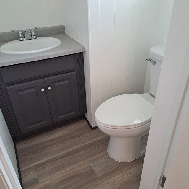 18433 Arcadia St, Lansing, IL 60438 - bathroom featuring vanity, toilet, wood finished floors, and a decorative wall