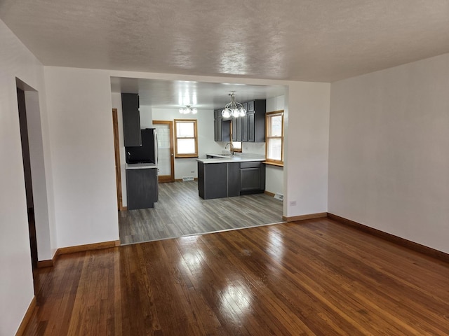 18433 Arcadia St, Lansing, IL 60438 - unfurnished living room featuring a chandelier, wood-type flooring, baseboards, and a sink