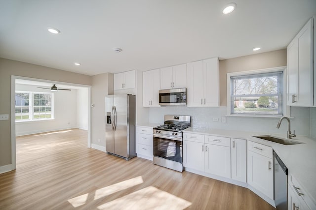 21967 Millard Ave, Richton Park, IL 60471 - kitchen featuring stainless steel appliances, a sink, light wood-style floors, backsplash, and light countertops