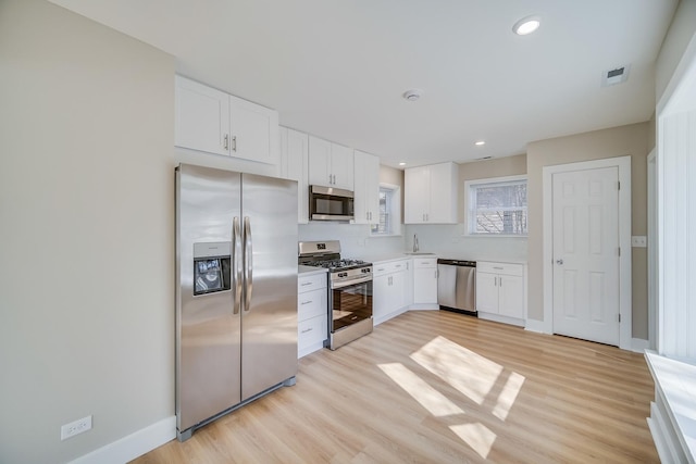 21967 Millard Ave, Richton Park, IL 60471 - kitchen featuring stainless steel appliances, light wood-style floors, white cabinets, baseboards, and light countertops