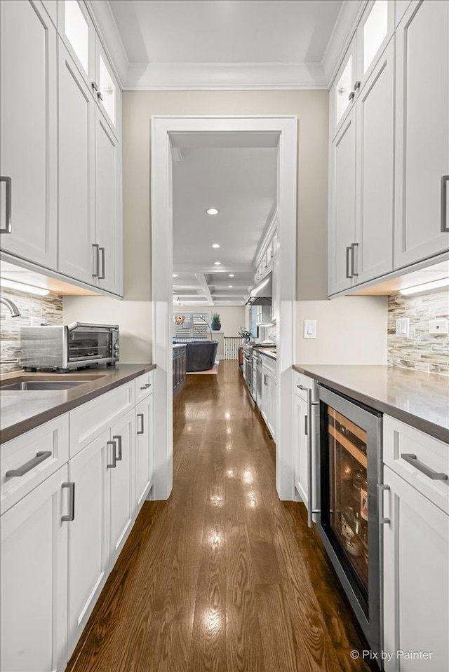 2426 W Warner Ave, Chicago, IL 60618 - kitchen with wine cooler, dark wood-style flooring, decorative backsplash, glass insert cabinets, and crown molding