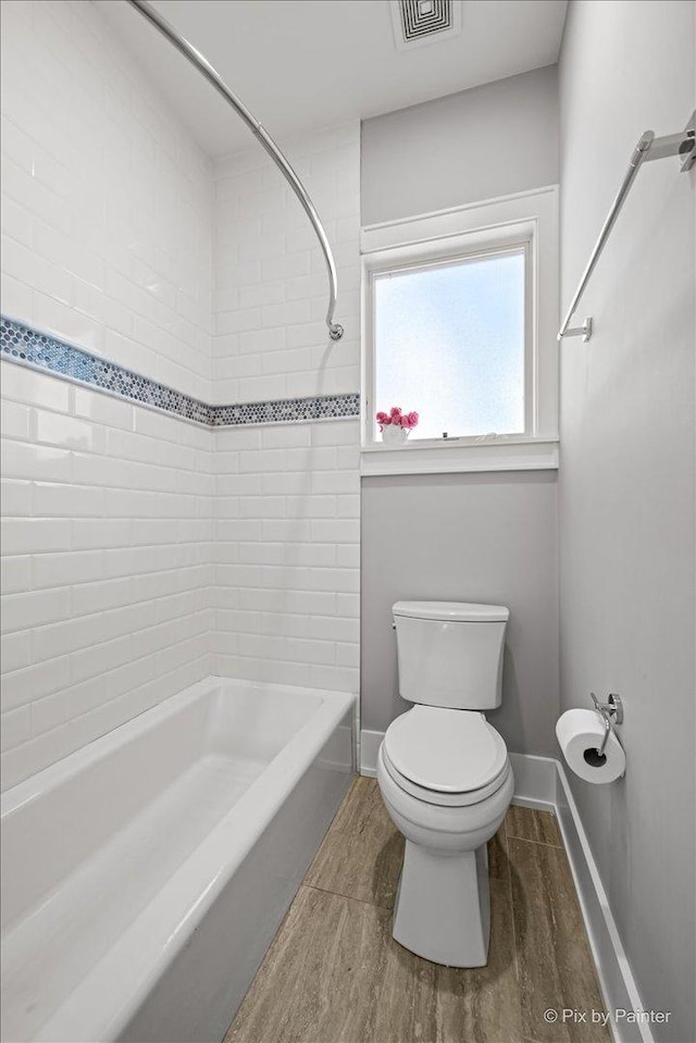 2426 W Warner Ave, Chicago, IL 60618 - bathroom featuring toilet, bathtub / shower combination, wood finished floors, and baseboards