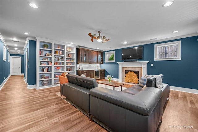 2426 W Warner Ave, Chicago, IL 60618 - living room with crown molding, recessed lighting, baseboards, light wood-style flooring, and a fireplace